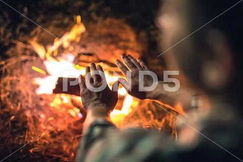 The man warming hands near the bonfire. night time Stock Photos