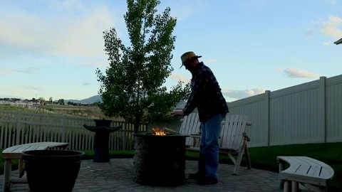 Man warming his hands at a backyard firepit Stock Footage 89768642