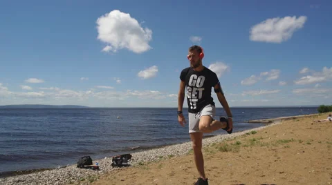 Man warming up before a jog along the river Stock Footage 68592984