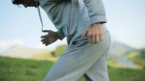 Man warming up in nature runs jogs uphill outdoors in countryside close up Stock Footage 79974761