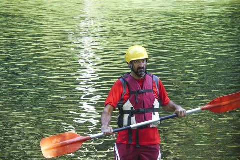 Man warming up with the paddle before kayaking Stock Photos