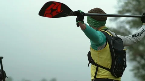 A man is warming up with a paddle on the shore Stock Footage 110293864