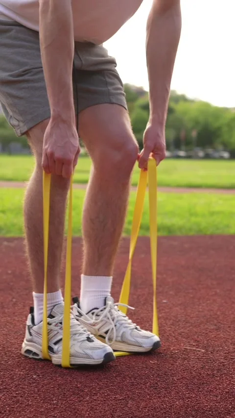 Man warming up with resistance elastic band outdoors Stock Footage 299896613