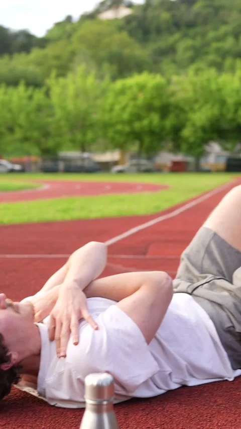 Man warming up stretching legs in an outdoor running track Stock Footage 299896583