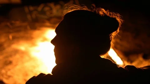 A man warms himself by the fire at night on the shore Stock Footage 115992537