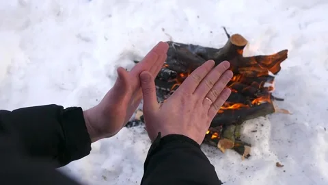 Man warms his hands by the campfire in winter Stock Footage 193116872
