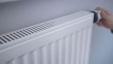 A man warms his hands with his fingers on the radiator Stock Footage 163589972