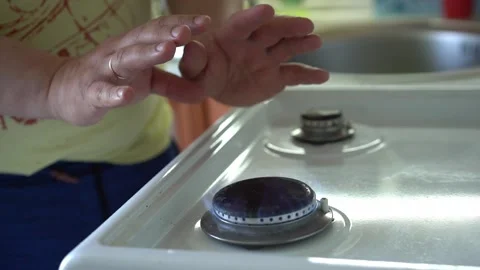 A man warms his hands over a gas stove. Heating in winter and the gas crisis Stock Footage 198009441