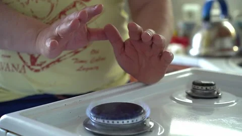 A man warms his hands over a gas stove. Heating in winter and the gas crisis Stock Footage 198009752