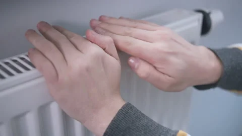 Man warms his hands by touching a battery, the heating season Stock Footage 160514197
