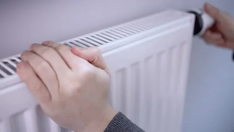 A man warms his palms by touching the battery Stock Footage 160059466