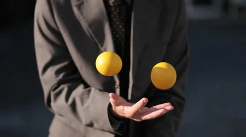 The man was effortlessly juggling 3 balls in the afternoon. Stock Footage