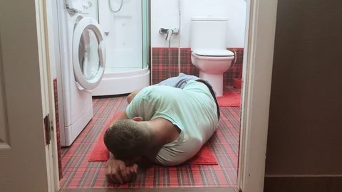 The man was lying on the floor of the bathroom, next to the toilet after an Stock-Footage 110885903