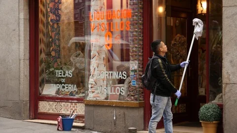 A Man wash Frontage Windows of a Store in Madrid, Spain Stock Footage 105914531