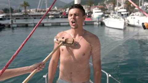 Man is washed with a brush on the deck of a yacht Stock Footage 103408261