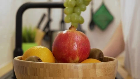 A man washed a bunch of grapes and put them on the fruit plate Stock Footage 129053889