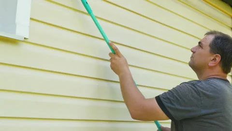 A man washes a building facade using a mop. Cleansing and maintenance service Stock Footage 201603131