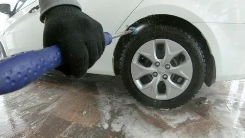 A man washes a car wheel Stock Footage 104281857