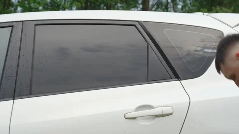 A man washes the car windows with a cloth before applying an anti-rain coating. Vídeos de archivo 336913761