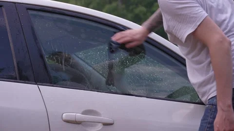 A man washes the car windows with a cloth before applying an anti-rain coating. 库存影片 336914007