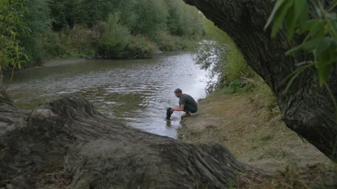 A man washes clothes in a river, in New Zealand Stock Footage 218386179