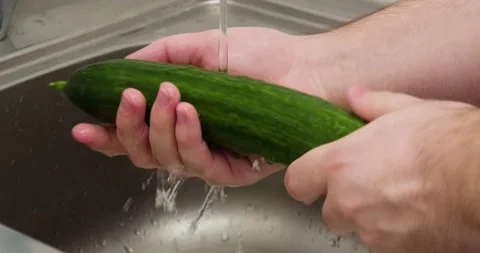 Man washes a cucumber Stock Footage 235512477
