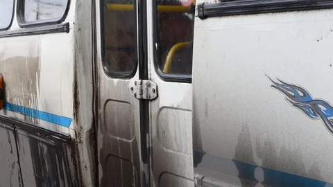A man washes a dirty bus in the open air Stock Footage 108012328