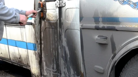 A man washes a dirty bus in the open air Stock Footage 108012330