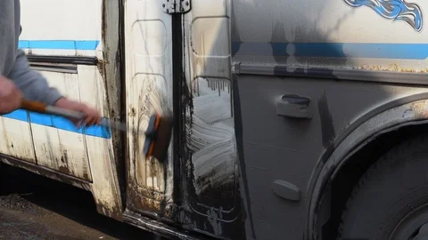 A man washes a dirty bus in the open air Stock Footage 108012332