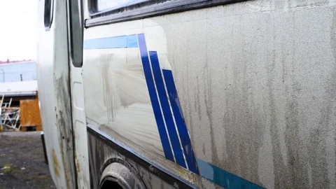 A man washes a dirty bus in the open air Stock Footage 108012333