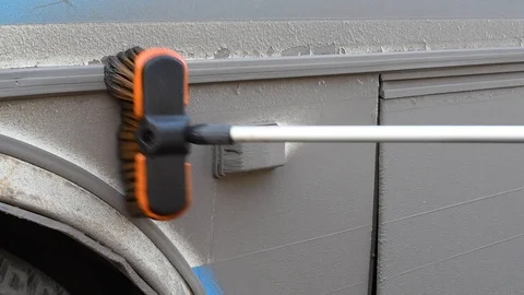 A man washes a dirty bus in the open air Video stock 108012334