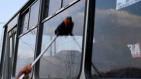 A man washes a dirty bus in the open air Stock Footage 108012343