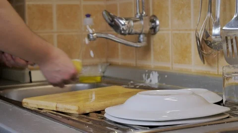 Man washes dirty dishes in kitchen Stock Footage 87305335