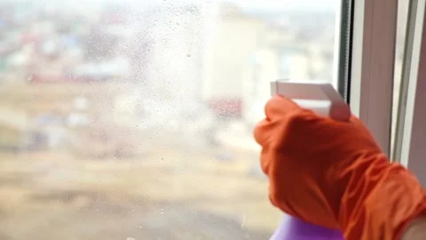 A man washes dirty old window. Removes tape. Stock Footage 169888086