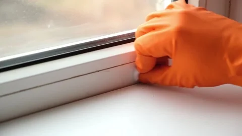 A man washes dirty old window. Removes tape. Stock Footage 169888175
