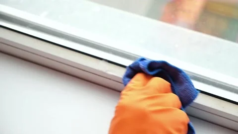 A man washes dirty old window. Removes tape. Stock-Footage 170402721