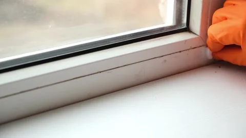 A man washes dirty old window. Removes tape. Video stock 171775239