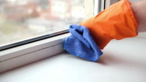 A man washes dirty old window. Removes tape. Stock Footage 172552534