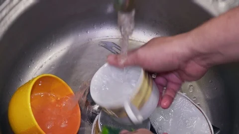 Man washes dishes in the kitchen close-up Stock Footage 104380158