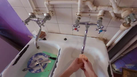 A man washes dishes with a sponge and dish detergent. From the first person. Video stock 332286644