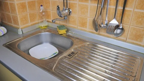 Man washes eating plate in kitchen Stock Footage 87299660
