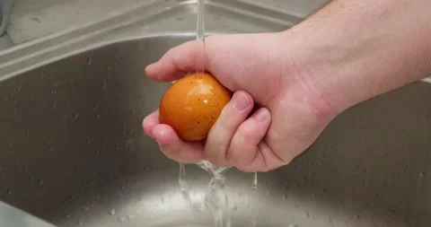 A man washes an egg Stock Footage 235512340