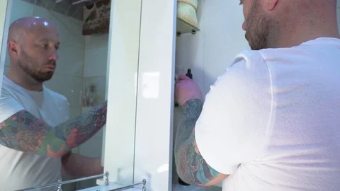 Man washes the face in the bathroom in isolation Stock Footage 127857265