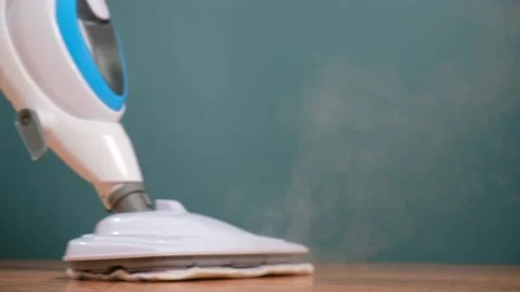 Man washes floors with steam mop. Floor treatment with hot steam. Hygienic Stock Footage 239278323