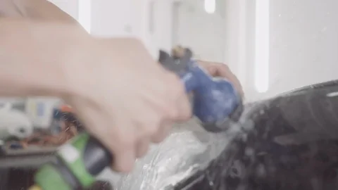 A man washes the front of the car before applying a protective layer on it Stock Footage 93603154