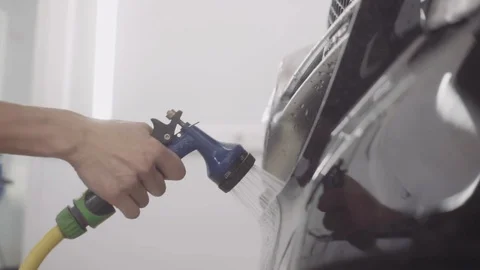 A man washes the front of the car before applying a protective layer on it Stock Footage 93603293