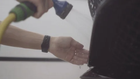 A man washes the front of the car before applying a protective layer on it Stock Footage 93603384