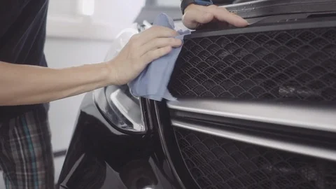 A man washes the front of the car before applying a protective layer on it Stock Footage 93603442