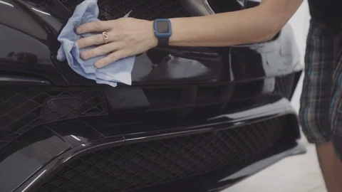 A man washes the front of the car before applying a protective layer on it Stock Footage 93603820
