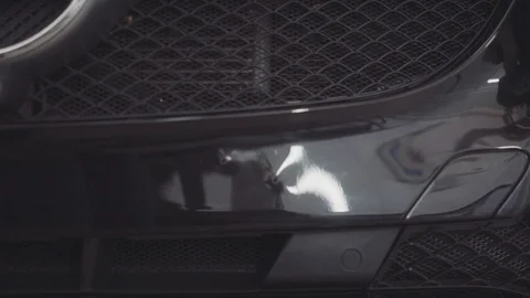 A man washes the front of the car before applying a protective layer on it Stock Footage 93603834